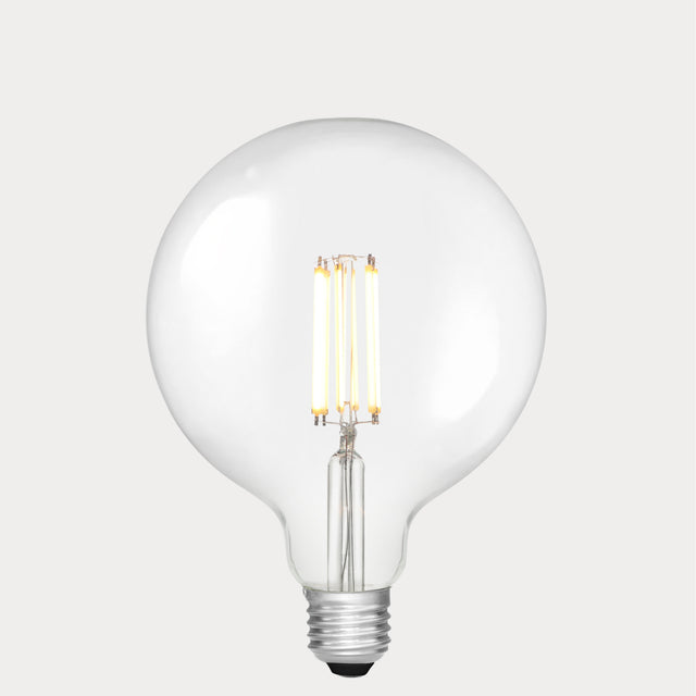 Dulora 11W E27 LED globe bulb in clear glass, glowing with 3000K soft white light.