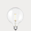 Dulora 7W E27 LED globe bulb in clear glass, glowing with 2700K warm white light.