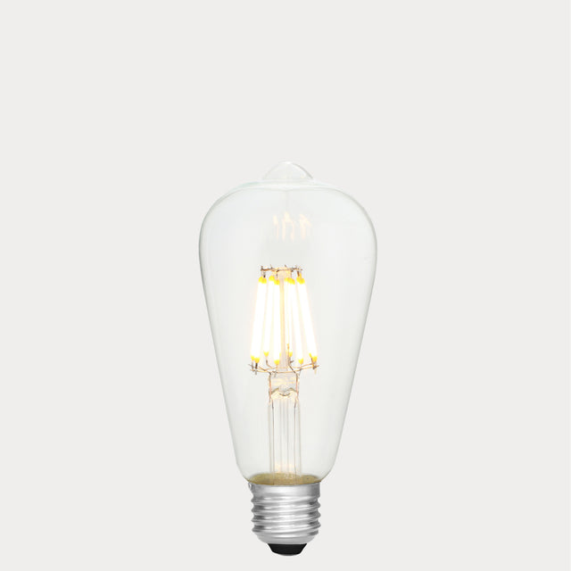 Dulora 8W E27 LED Edison-style bulb in clear glass with AC/DC compatibility, glowing with 2700K warm white light.